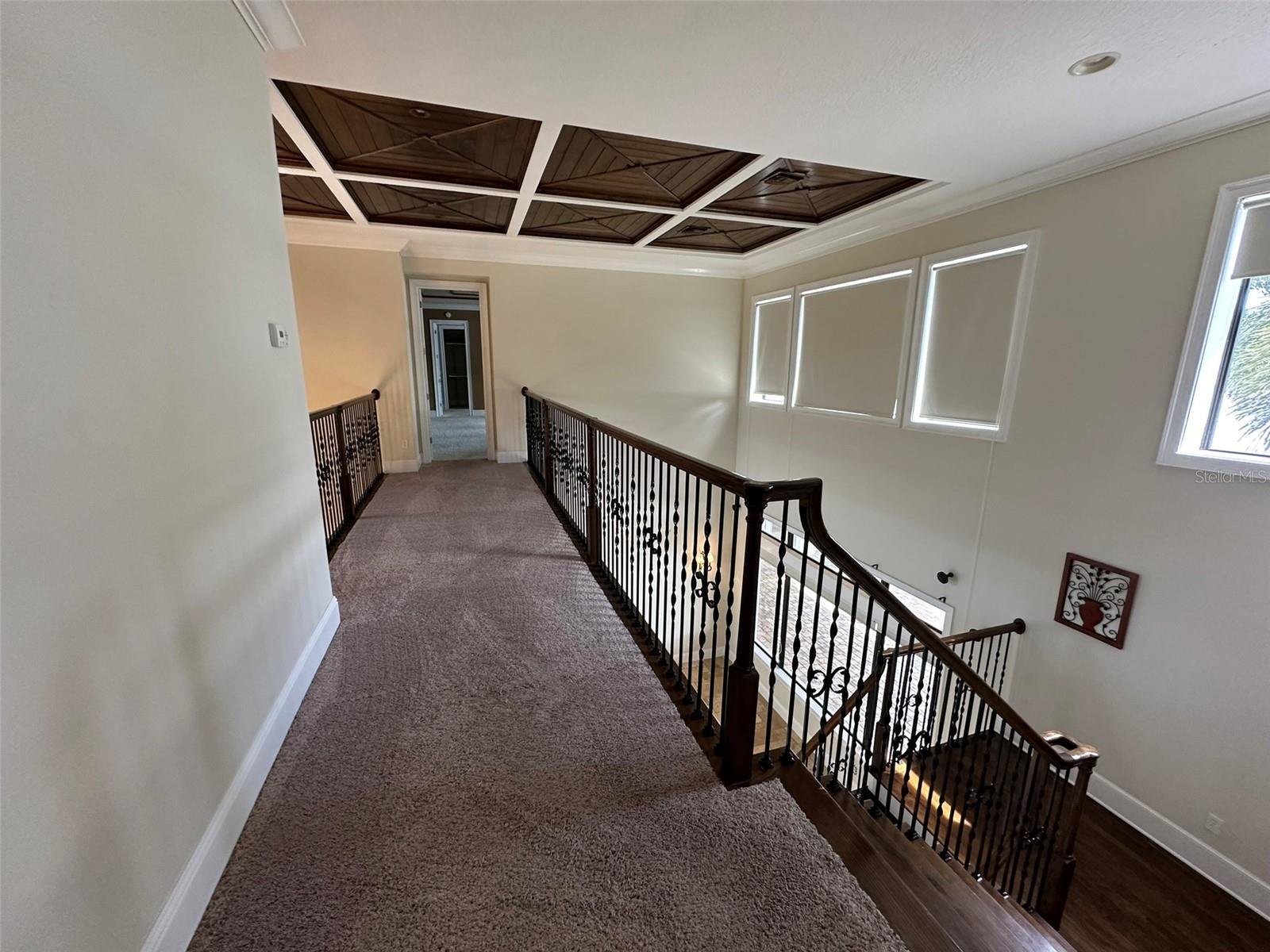 second floor stairway with dark carpet